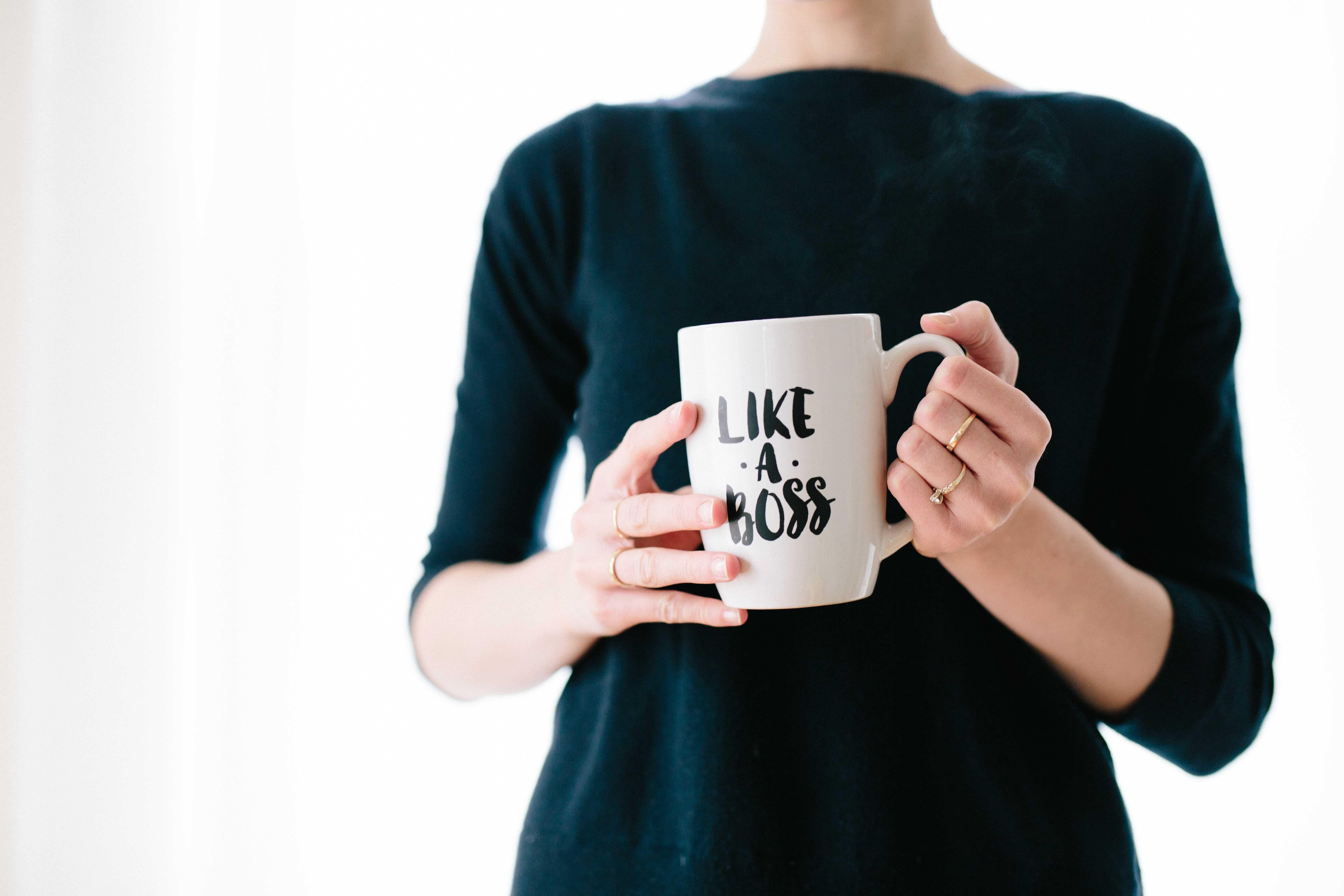 A stock image of a woman holding a mug with 'Like a Boss' on its side.